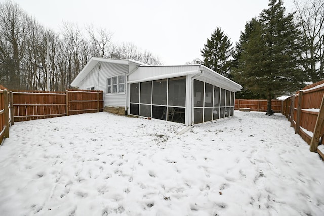 snow covered property with a sunroom