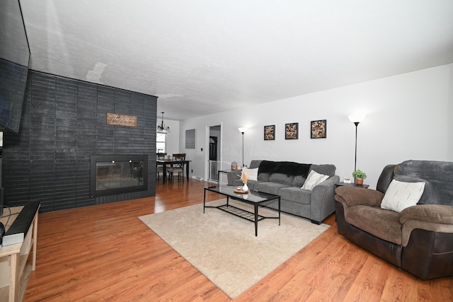 living room featuring light wood-type flooring and a tiled fireplace