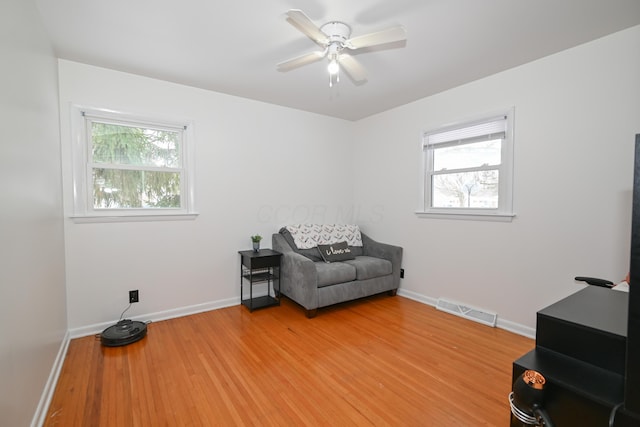 living area with ceiling fan and light wood-type flooring