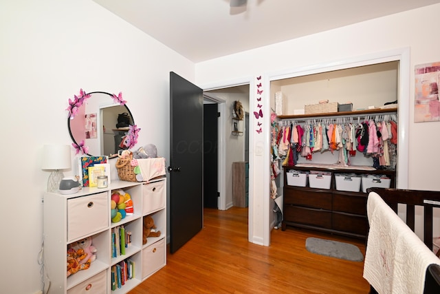 bedroom featuring a closet, a nursery area, and light hardwood / wood-style flooring