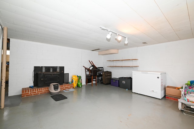 garage with a wood stove and fridge