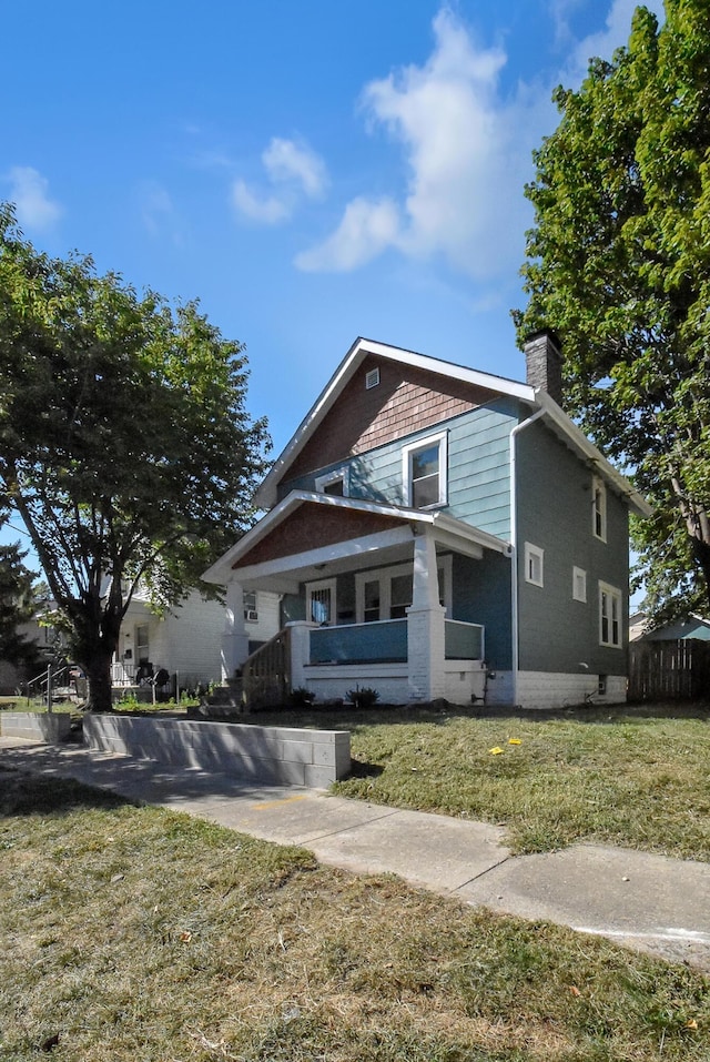 view of front of house with covered porch and a front lawn