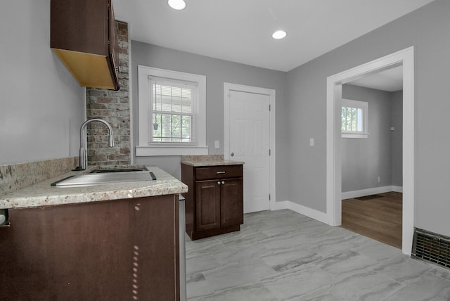 kitchen with dark brown cabinets, a wealth of natural light, and sink