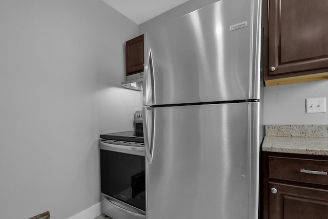 kitchen featuring appliances with stainless steel finishes, dark brown cabinetry, and range hood