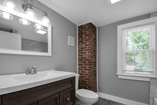 bathroom featuring vanity, wood-type flooring, and toilet