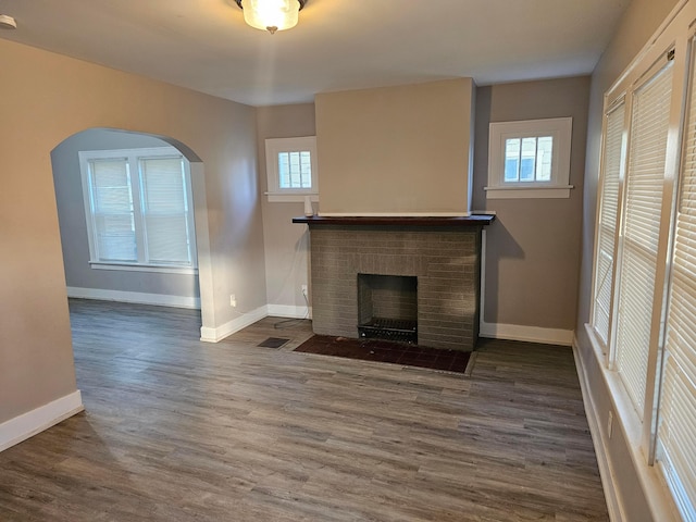 unfurnished living room with a fireplace and dark hardwood / wood-style floors