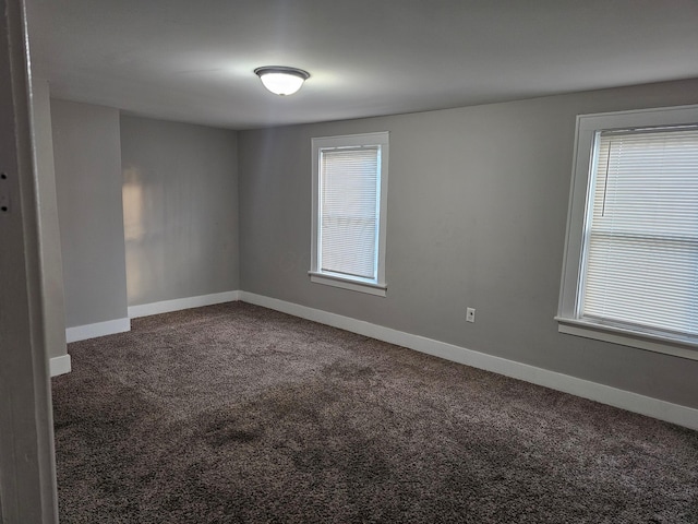 unfurnished room featuring dark carpet