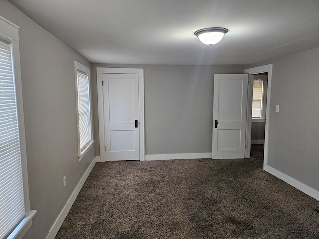 unfurnished room with dark colored carpet