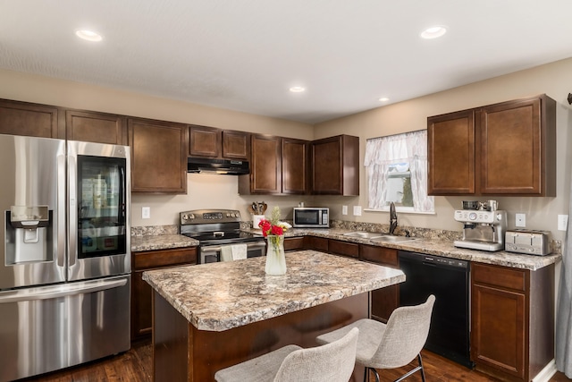 kitchen featuring a kitchen island, appliances with stainless steel finishes, sink, and dark hardwood / wood-style floors