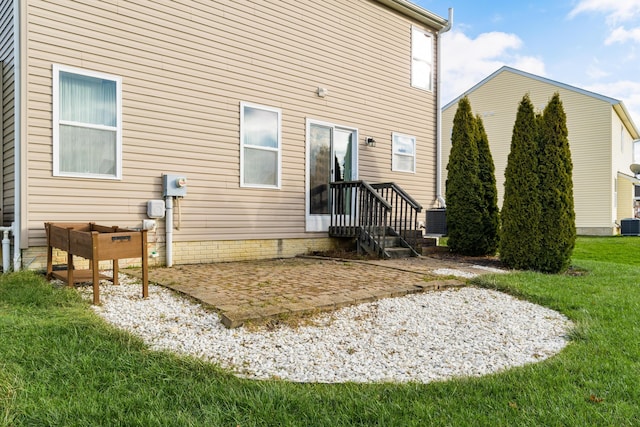 rear view of property featuring cooling unit, a lawn, and a patio area