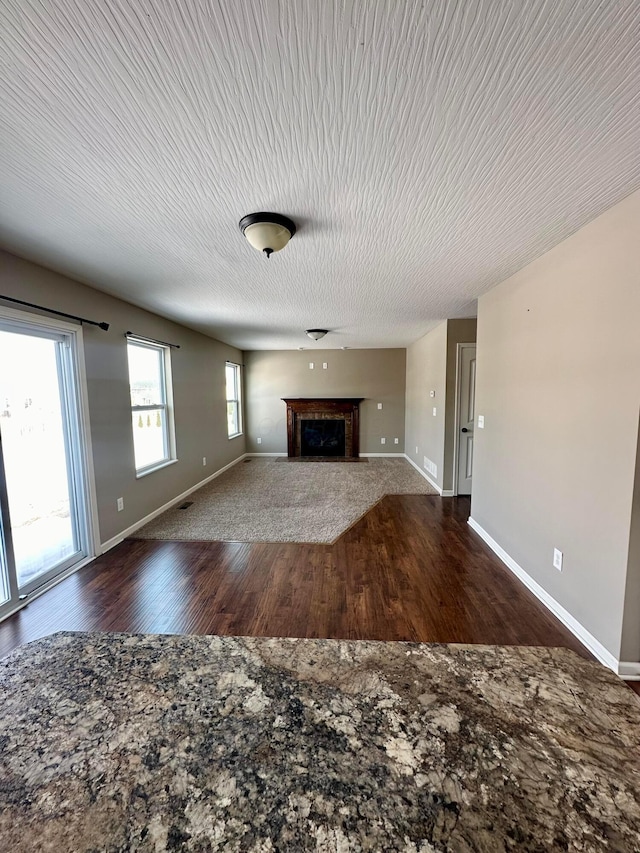 unfurnished living room with dark wood-type flooring