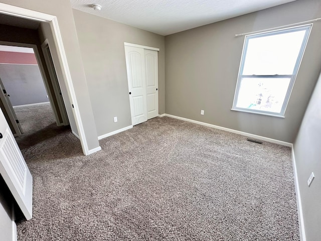 unfurnished bedroom featuring carpet and a closet