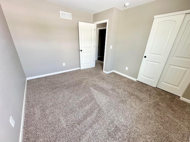 unfurnished bedroom featuring carpet and a closet