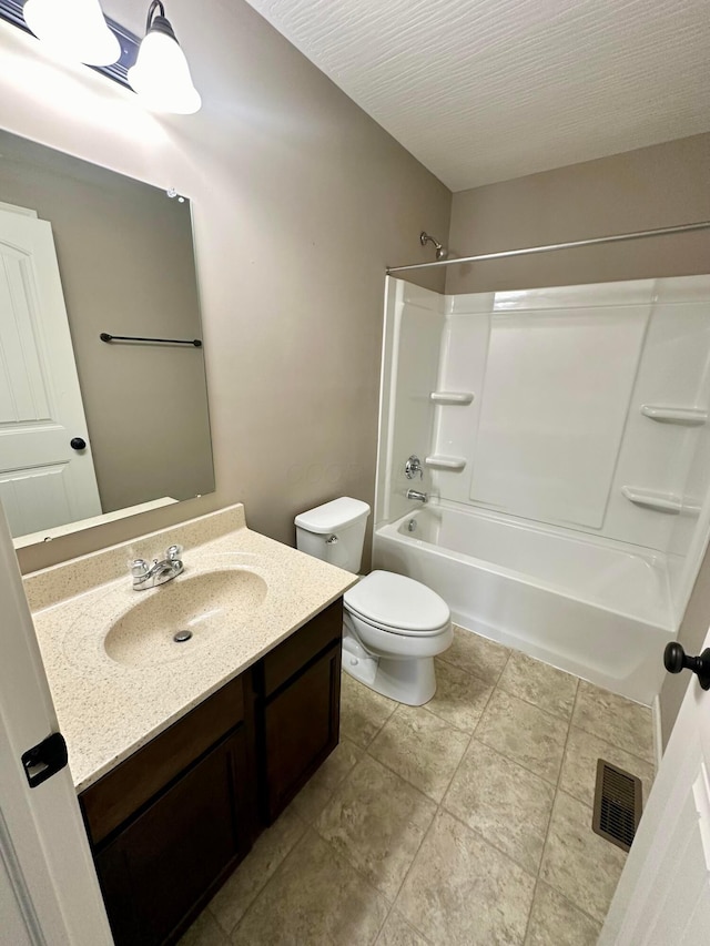 full bathroom with vanity, a textured ceiling, washtub / shower combination, and toilet