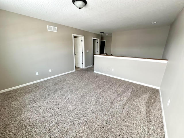 carpeted empty room with a textured ceiling