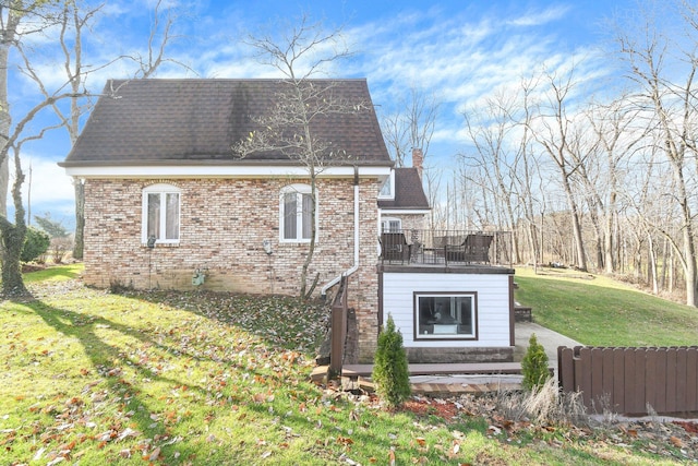 view of side of property with a balcony and a lawn