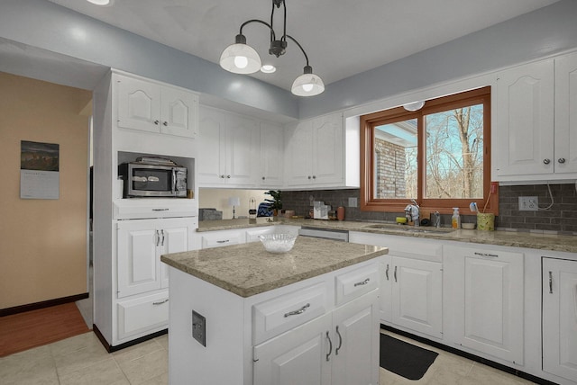 kitchen with sink, a center island, white cabinets, pendant lighting, and backsplash