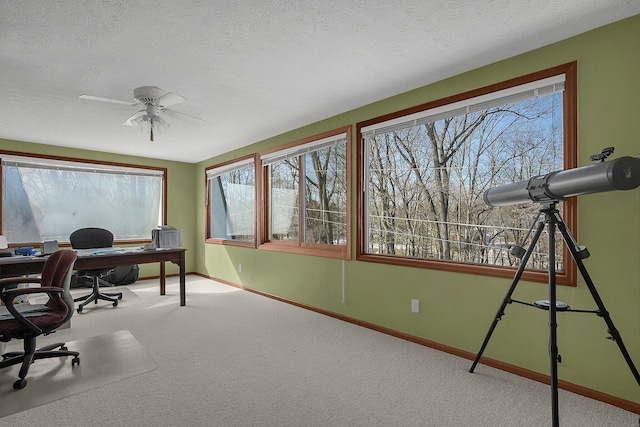 carpeted office space featuring ceiling fan and a textured ceiling