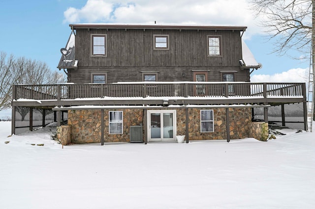 snow covered rear of property featuring a deck and central air condition unit