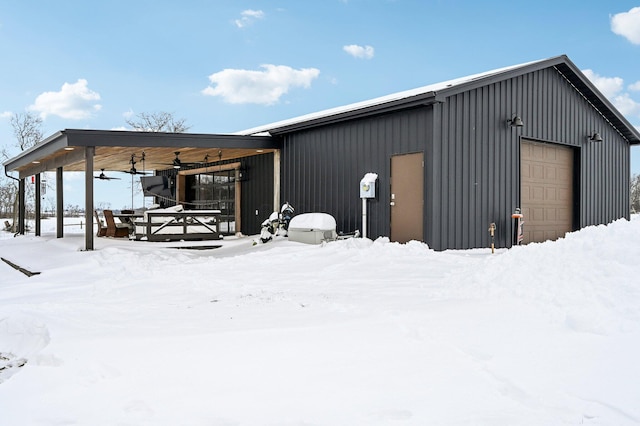 snow covered structure featuring a garage