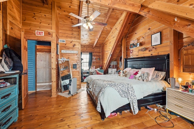 bedroom with beamed ceiling, ceiling fan, wooden ceiling, and wooden walls