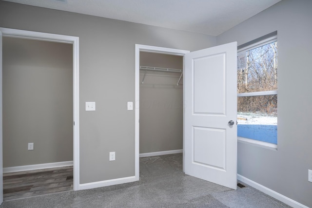 unfurnished bedroom with a closet and dark colored carpet