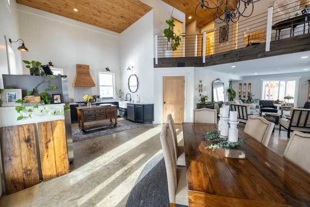 dining area with plenty of natural light, high vaulted ceiling, wood ceiling, and a notable chandelier