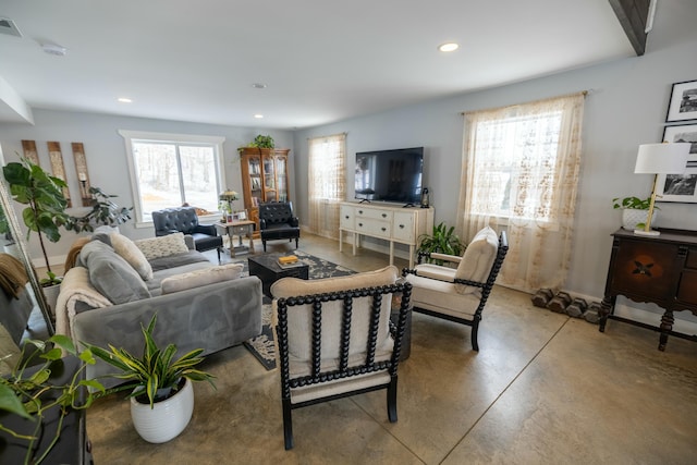 living room featuring concrete floors and a healthy amount of sunlight