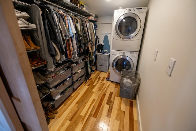 laundry room featuring hardwood / wood-style floors and stacked washer and clothes dryer