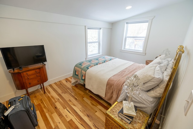 bedroom featuring light hardwood / wood-style floors and lofted ceiling