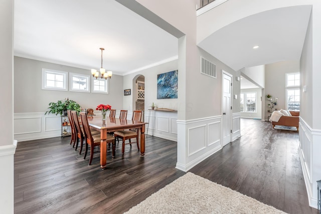 dining room featuring a chandelier, crown molding, and dark wood-type flooring