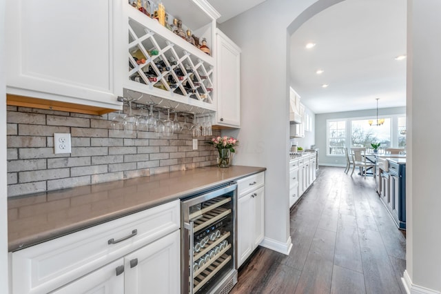 bar featuring wine cooler, decorative backsplash, white cabinets, and pendant lighting