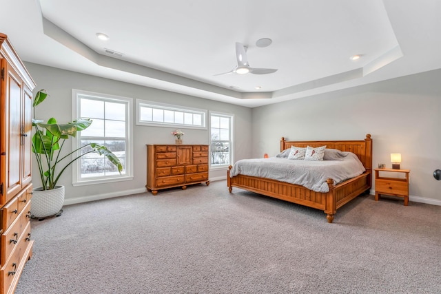 bedroom with carpet, a tray ceiling, and ceiling fan