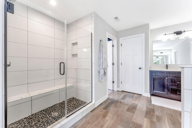 bathroom featuring vanity and a shower with door