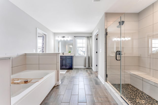 bathroom featuring plus walk in shower and vanity