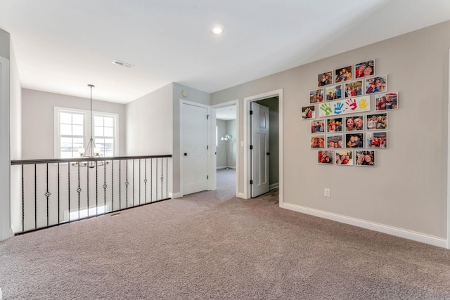 unfurnished room featuring carpet and a chandelier