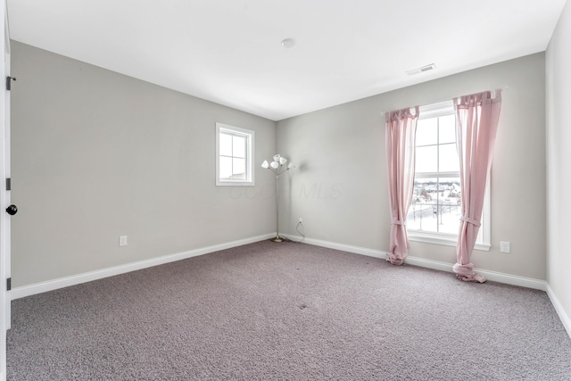 carpeted empty room featuring plenty of natural light