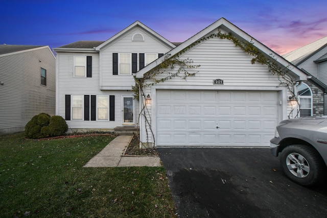 view of front of home with a yard and a garage