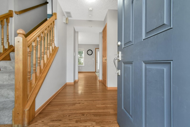 hall featuring hardwood / wood-style flooring and a textured ceiling