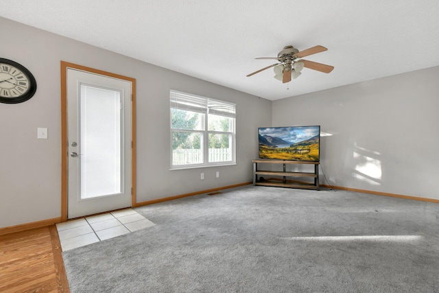 unfurnished living room with ceiling fan and light carpet