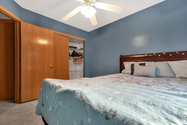 bedroom featuring light carpet, a textured ceiling, a closet, and ceiling fan