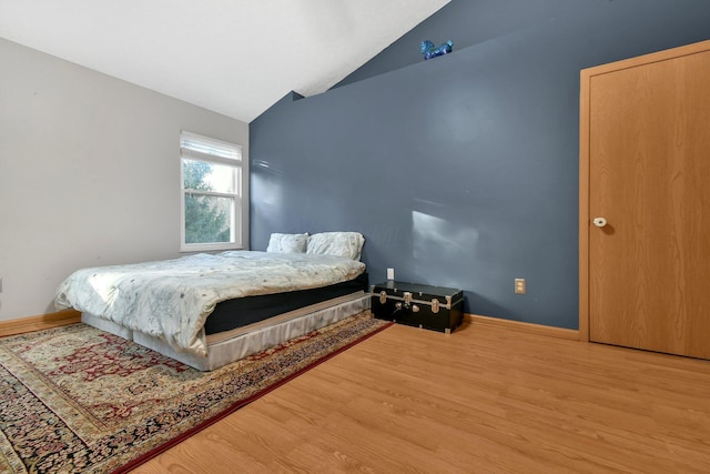 bedroom featuring wood-type flooring and vaulted ceiling