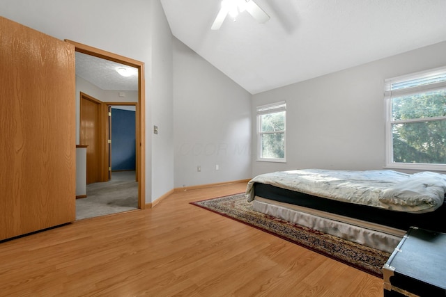 bedroom with ceiling fan, hardwood / wood-style floors, and lofted ceiling