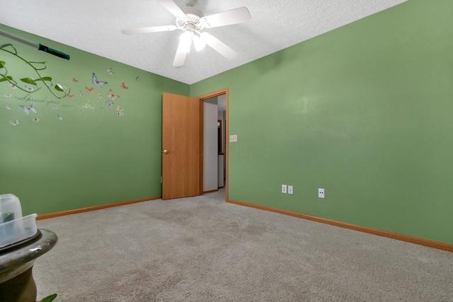 unfurnished room with ceiling fan, light colored carpet, and a textured ceiling