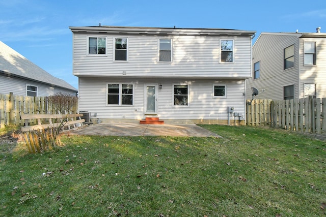 back of house with central air condition unit, a patio area, and a lawn