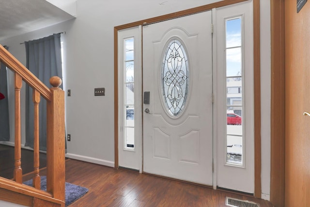 entrance foyer featuring dark hardwood / wood-style flooring and a healthy amount of sunlight