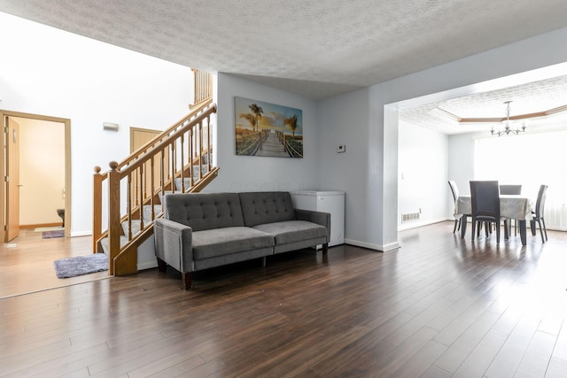 living room featuring a chandelier, a textured ceiling, and hardwood / wood-style flooring