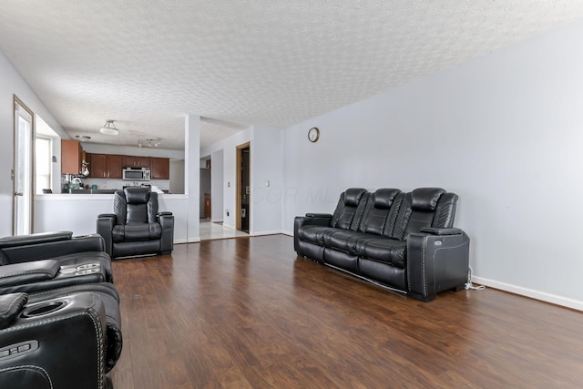 living room with a textured ceiling and dark wood-type flooring