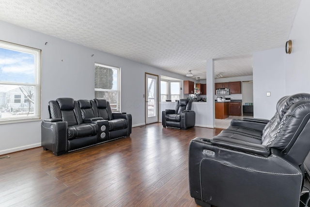 living room with a textured ceiling, dark hardwood / wood-style floors, and ceiling fan