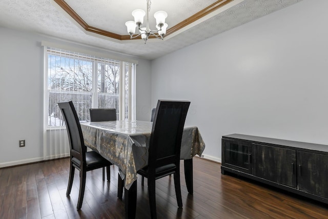 dining area featuring an inviting chandelier, crown molding, dark hardwood / wood-style floors, a textured ceiling, and a tray ceiling